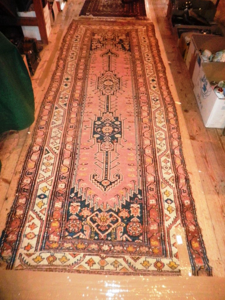 A mid-twentieth century Persian wool runner, having double lozenge pole medallion on a raspberry