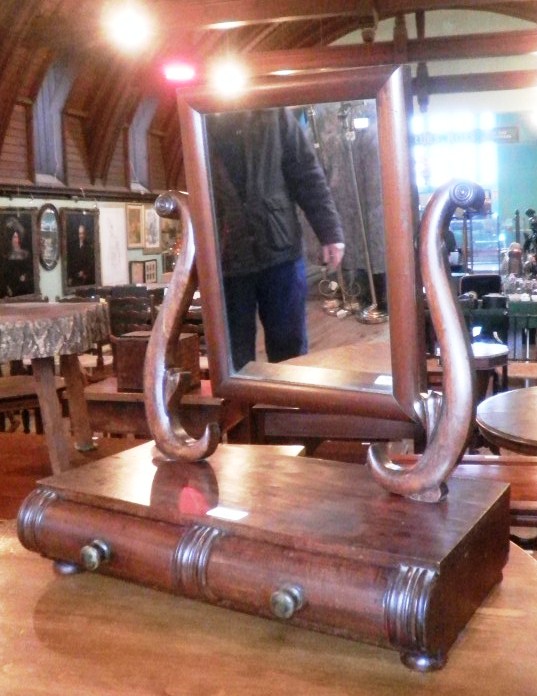 A Victorian mahogany toilet mirror, having a plain rectangular plate within scrolled horns, on a two