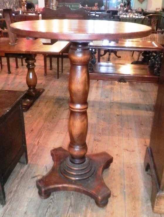 A 20th century pub table, having circular top, baluster column on concave plateau and bun feet.