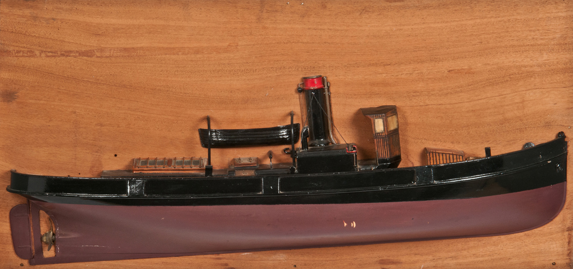 A HALF-BLOCK MODEL OF A TUG BOAT, the carved hull with brass propeller and rudder, painted deck with