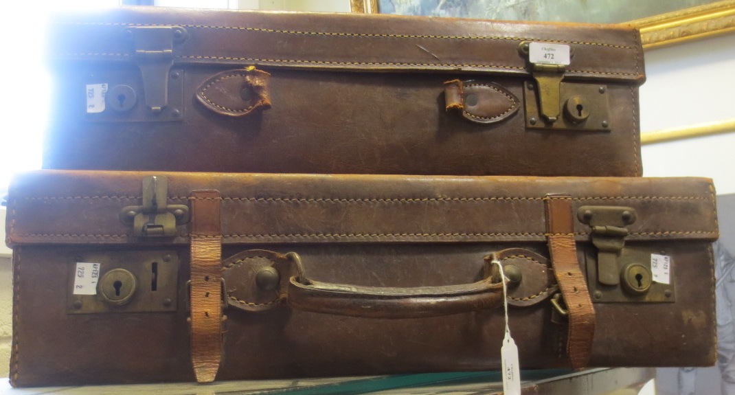 A leather suitcase with brass mounts and another (2) A leather suitcase with brass mounts and