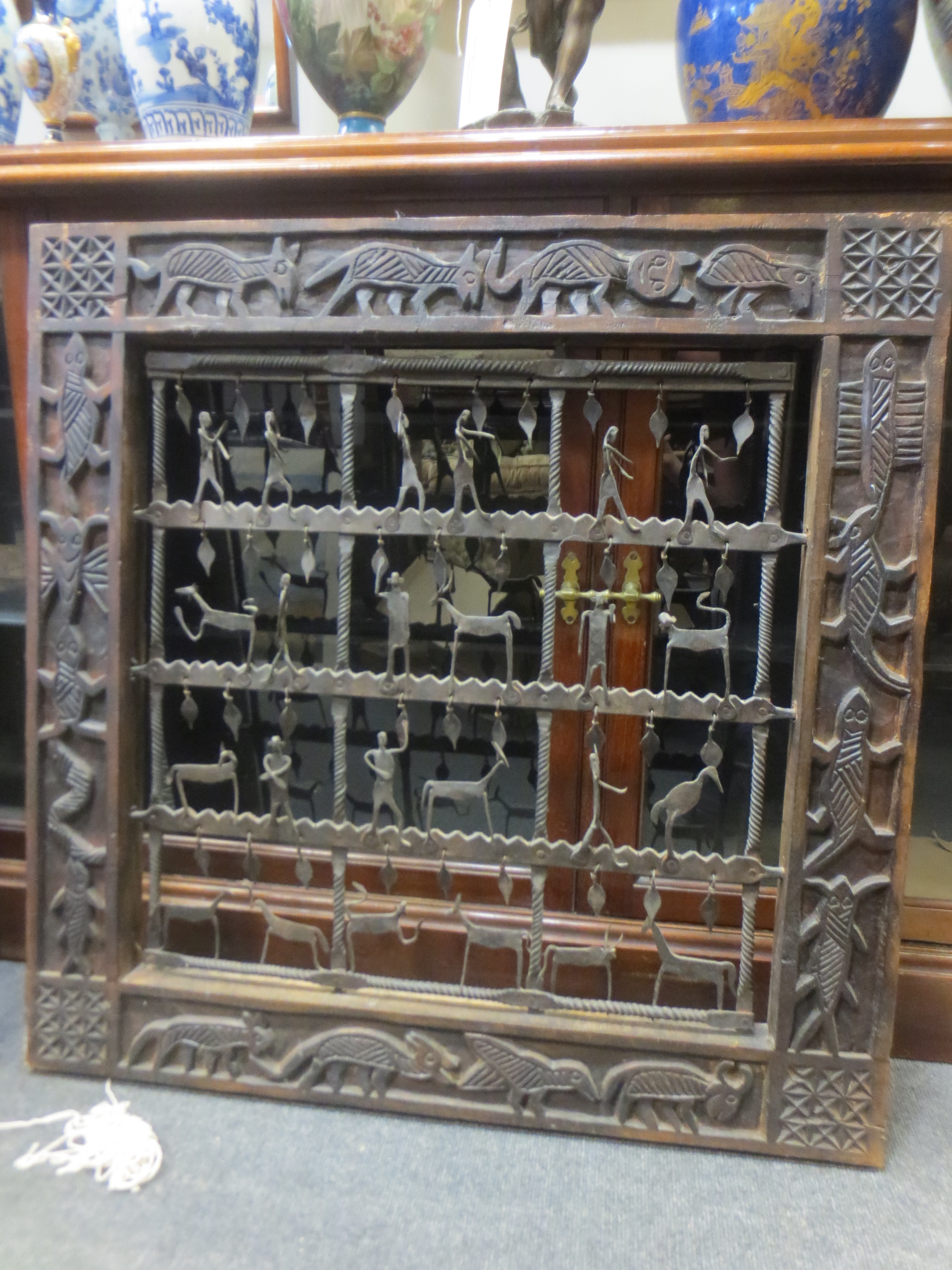 An african carved framed iron sculpture of figures and animals An african carved framed iron
