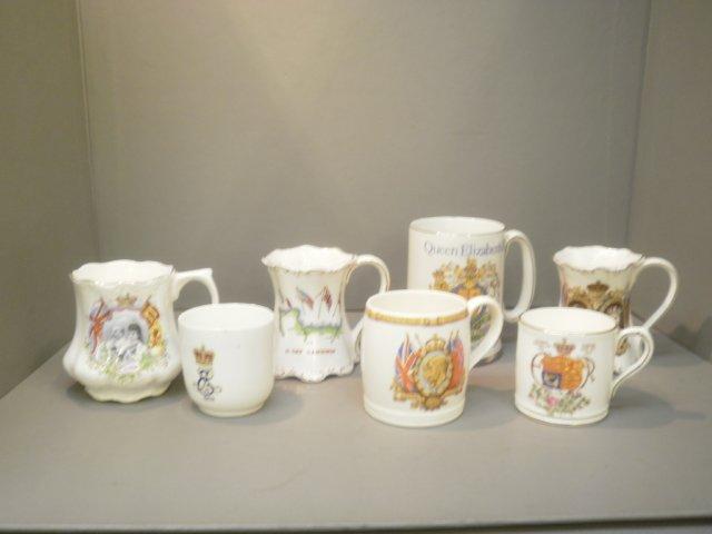 An assortment of commemorative ceramics including two translucent cups and saucers, King Edward