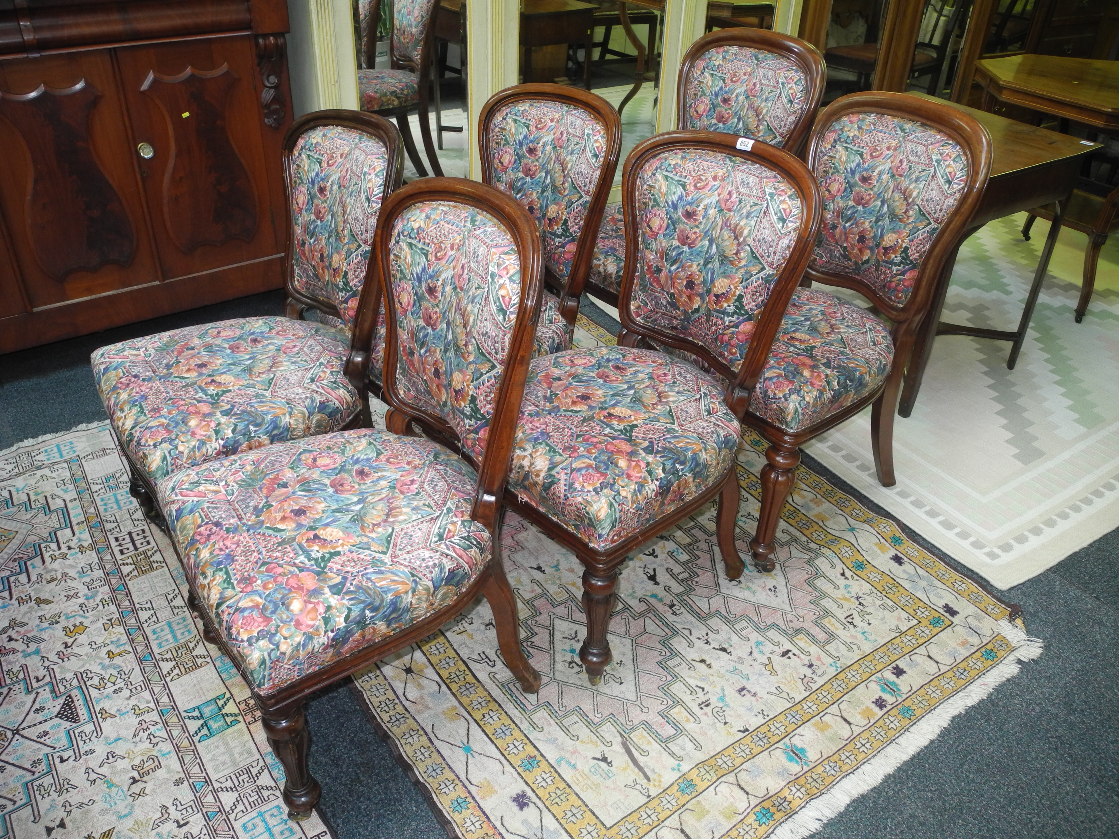 Six 19th Century mahogany dining chairs upholstered in a floral material raised on lobed and
