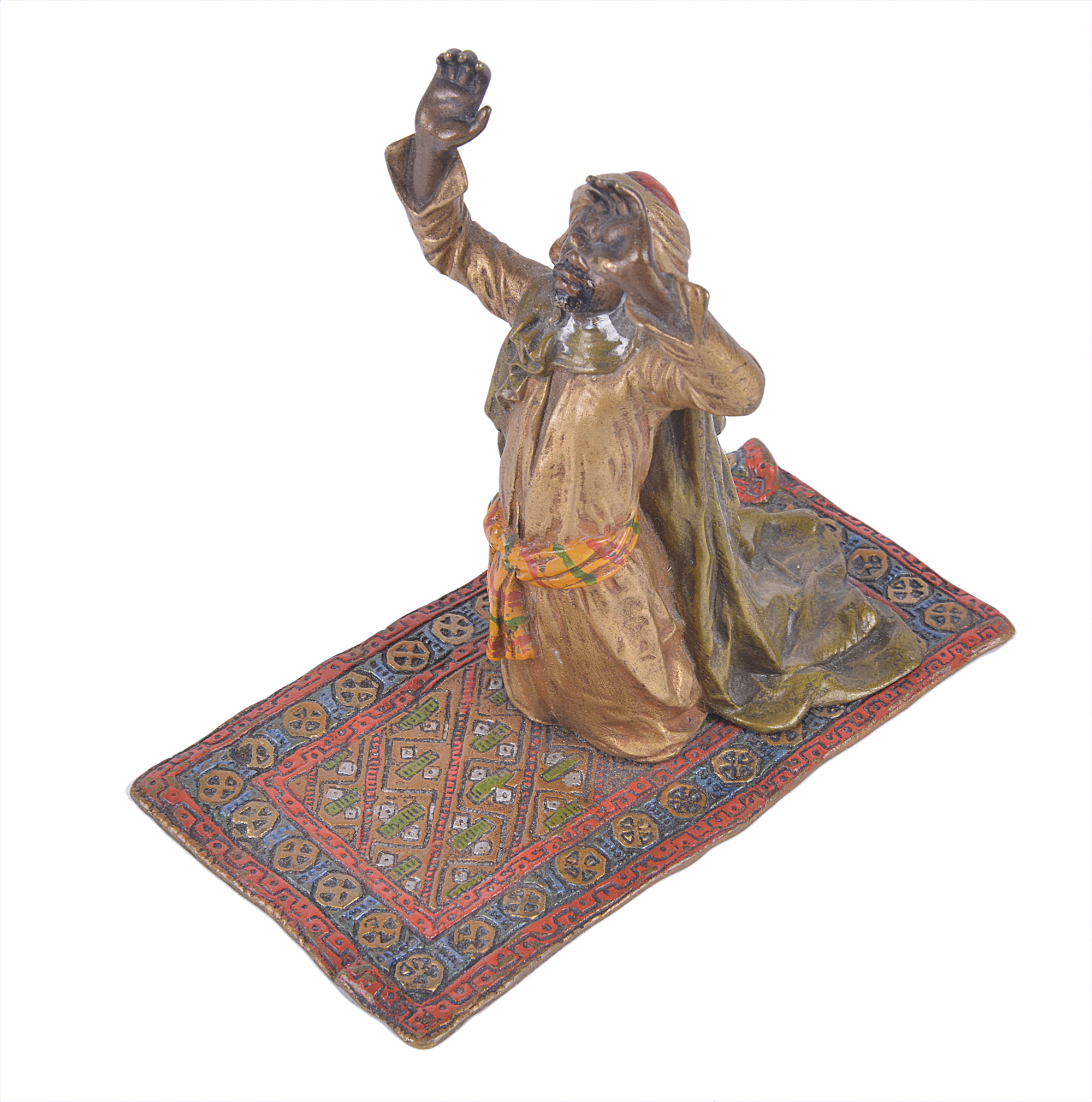 A Bergman, Austrian cold painted bronze of a man in turban kneeling on carpet with his hands raised,