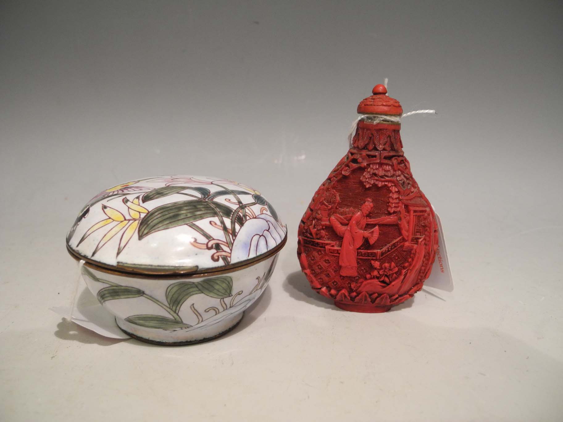 A 20th Century Chinese red glazed cinnabar lacquered snuff bottle and stopper, carved in deep relief