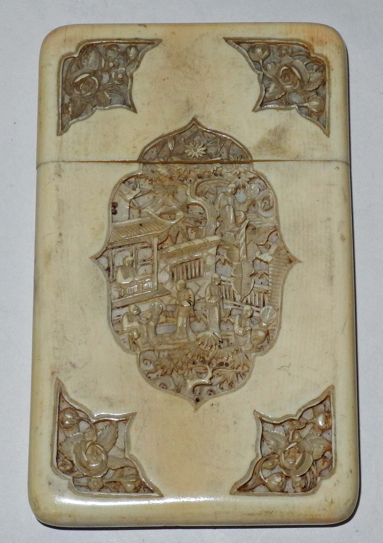 A 19th Century Chinese Canton ivory card case, with cartouche carved panels with figures in a