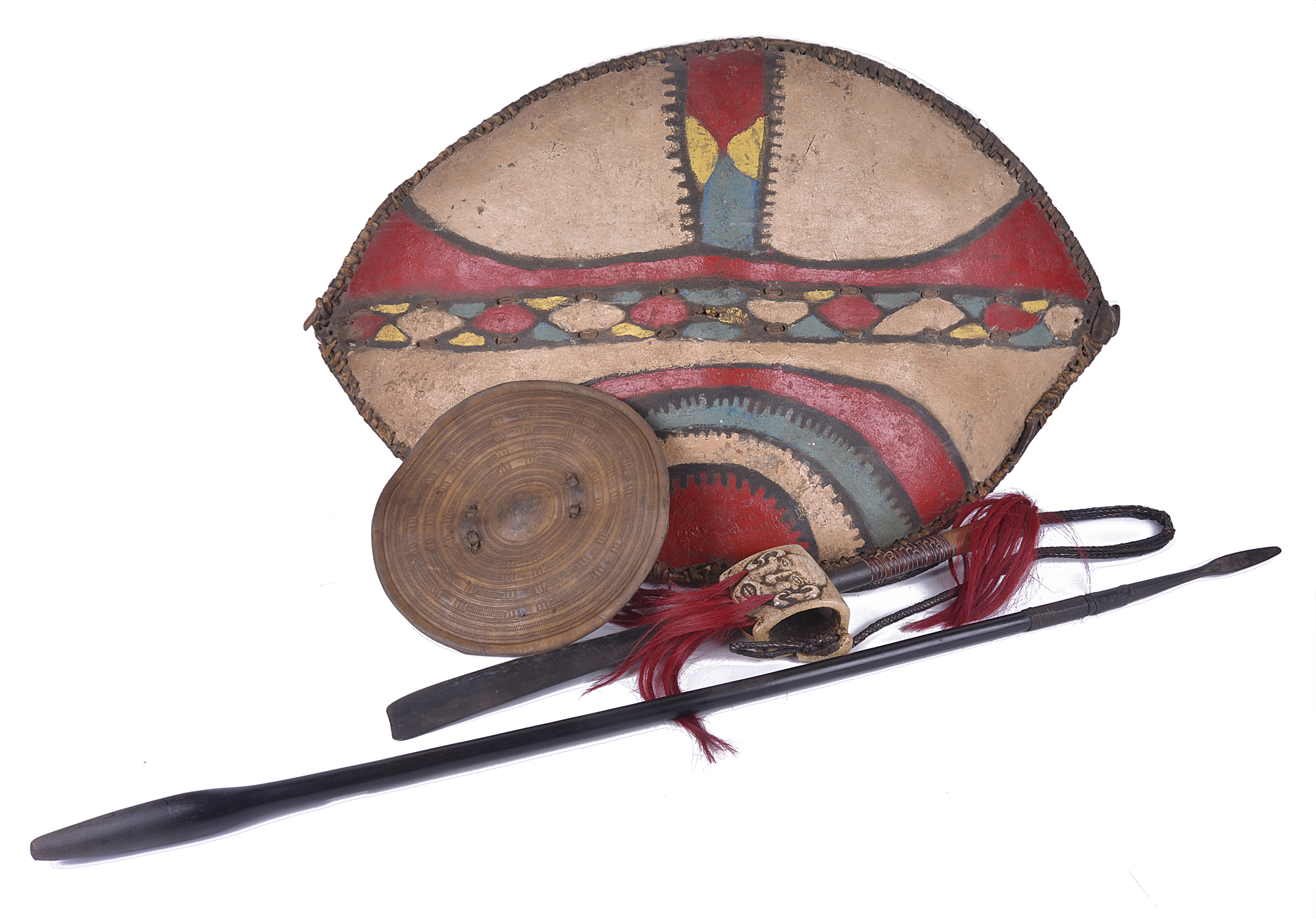 A tribal machete with carved bone and plaited leather hanger, a spear, a polychromed hide shield and