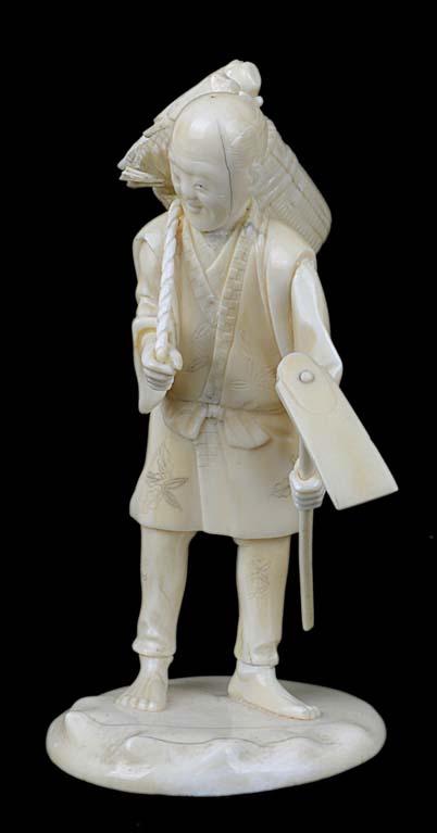 A Japanese antique ivory okimono of a labourer, standing with an axe.13.5cm