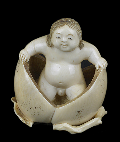 A fine and rare 19th Century Japanese carved ivory of a young immortal emerging from a peach