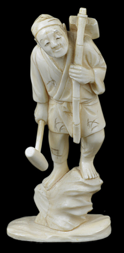 An antique Japanese ivory okimono of a man standing on a rock with a mallet, signed Tamayuki.13cm