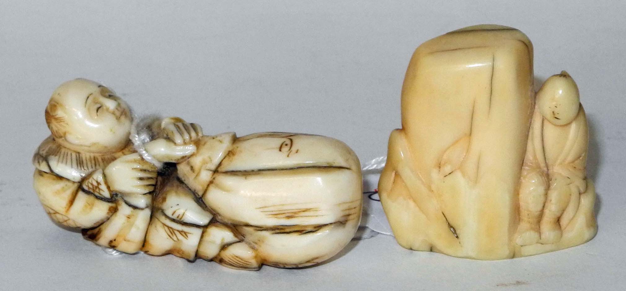 An antique ivory netsuke of a man seated by a rock, and another of a man seated with a large bag. (