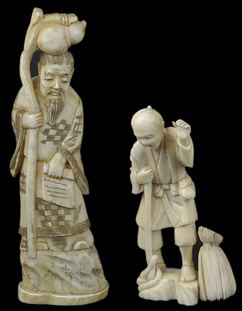 An antique Japanese ivory okimono of an elderly man with a bag at his feet, together with another of