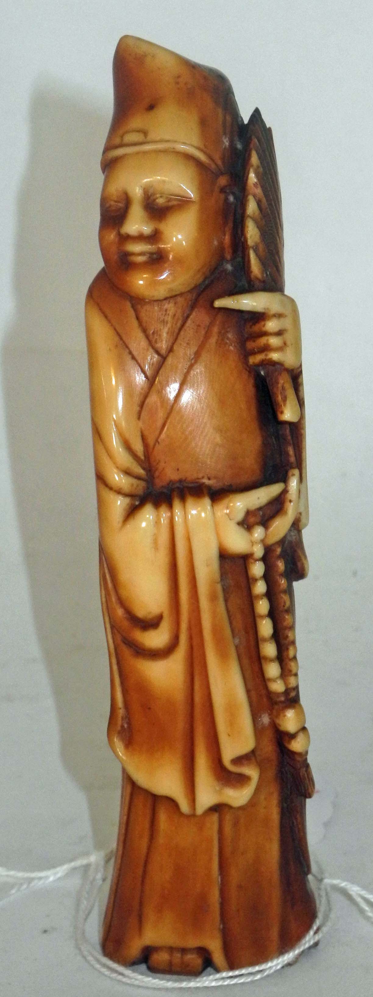 An antique Chinese carved and stained ivory figure of a court official 13.5cm high