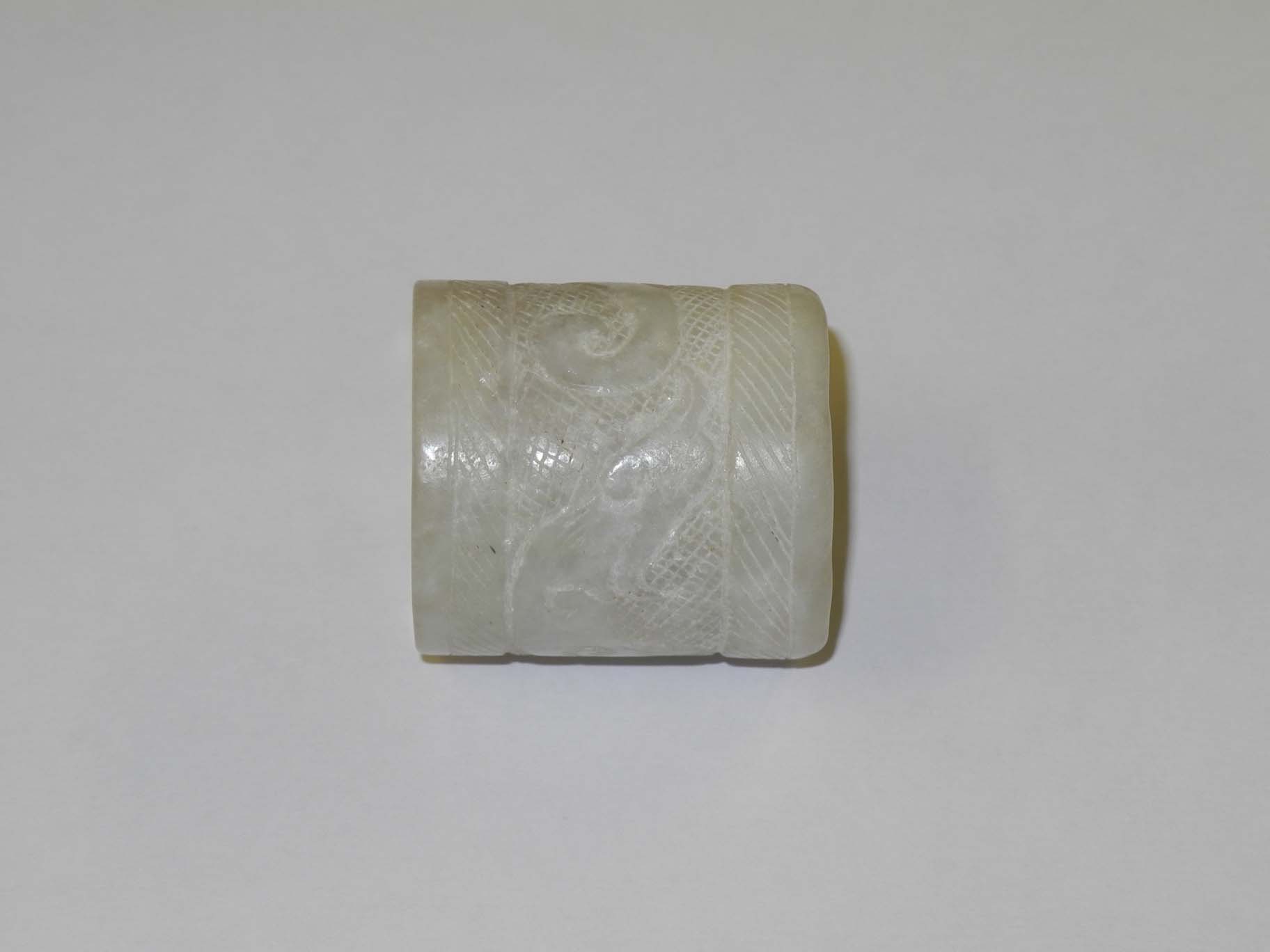 A Chinese 17th Century Kangxi period white jarde archer`s thumb ring, with carved dragon coiled