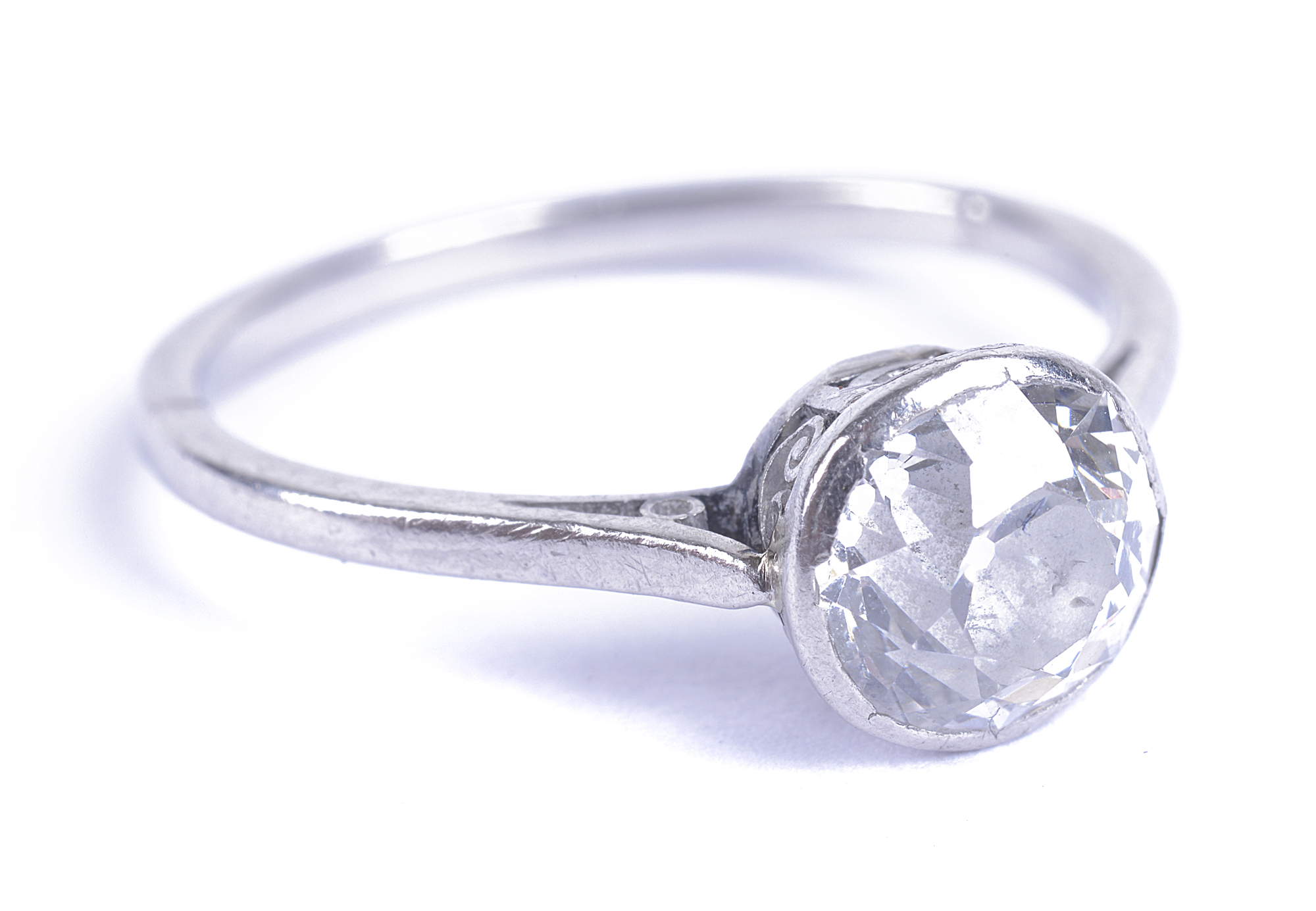 A good Art Deco white metal and diamond solitaire ring, the old round cut stone collet set into a