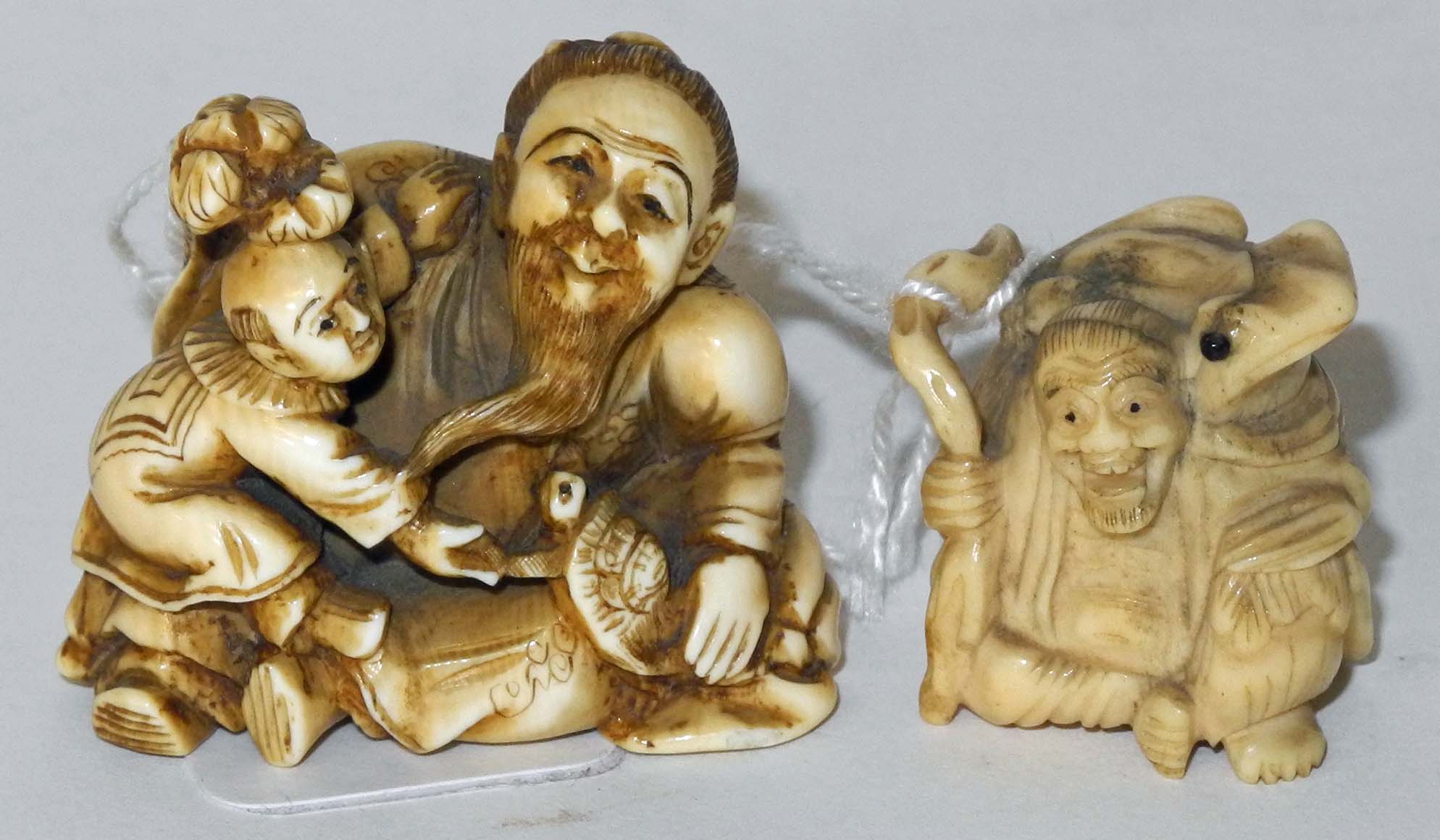 A Japanese ivory netsuke of an elderly man seated with a child and turtle, signed, together with