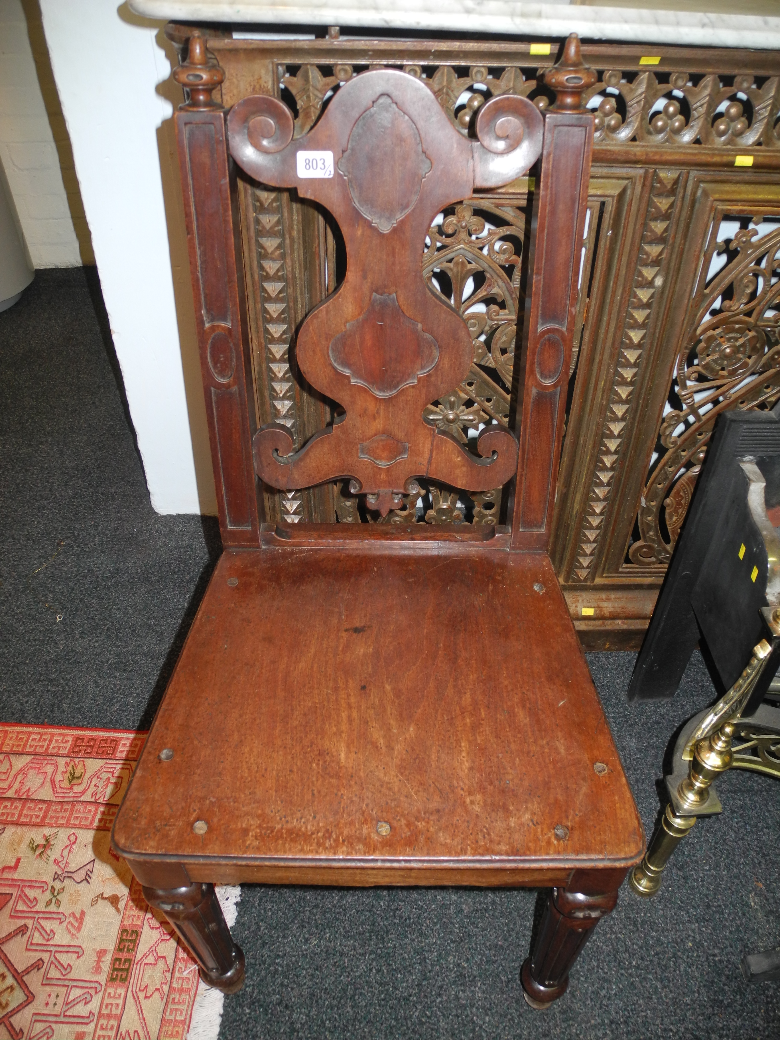 A pair of 19th Century solid seat mahogany chairs of Pugin influence, with finials above shaped