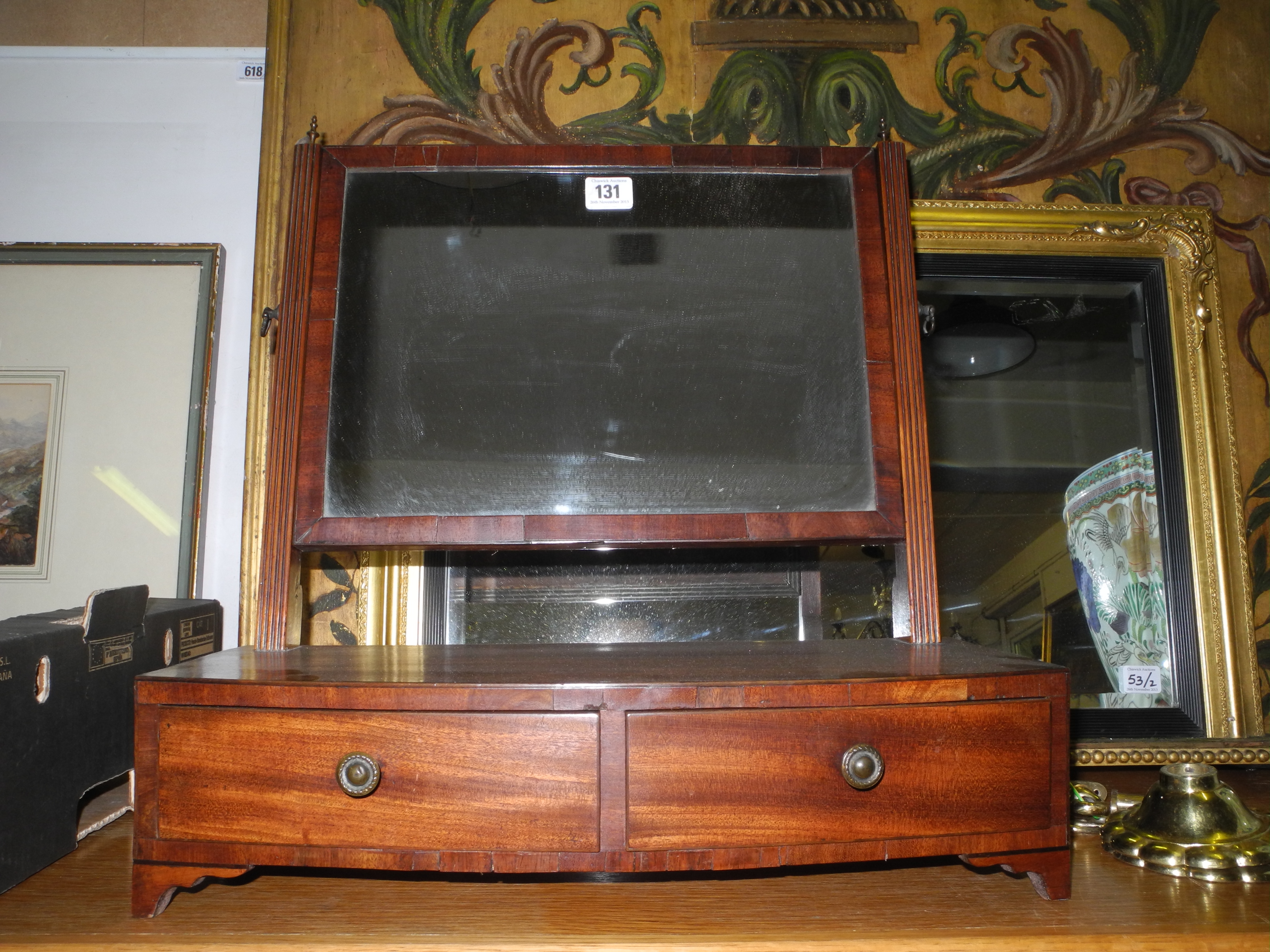 A late Victorian mahogany framed vanity swing mirror, having two drawers, raised on small bracket