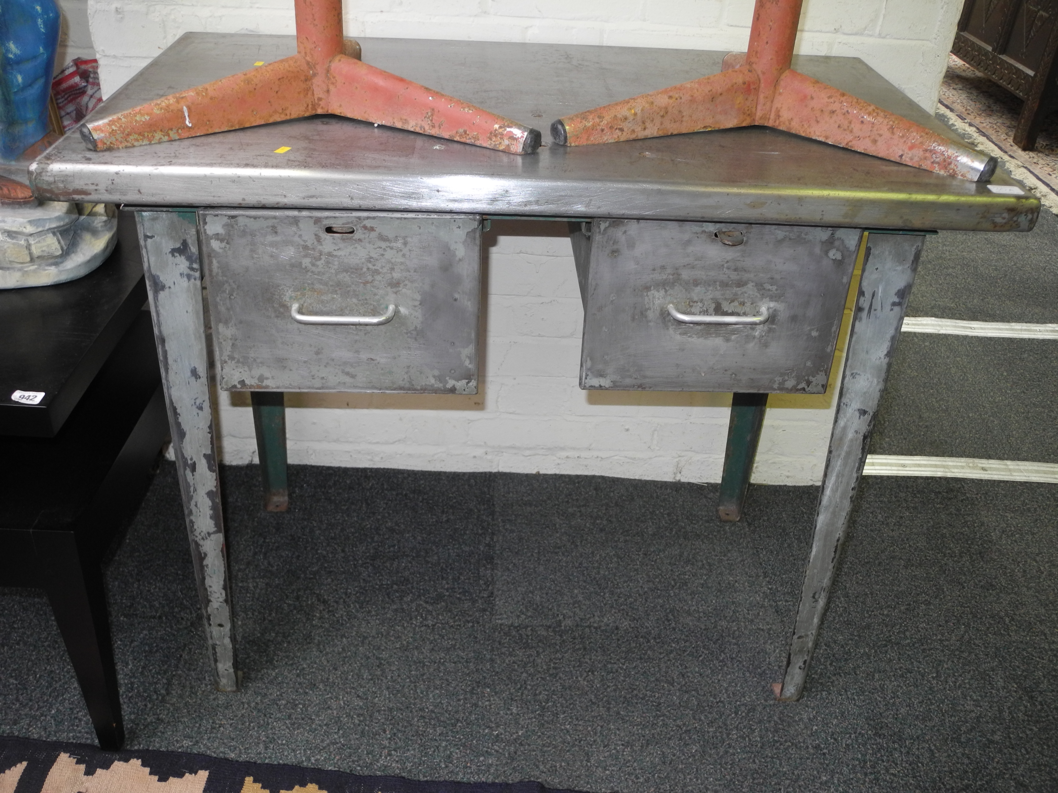 A distressed finished metal industrial/mechanic`s work bench, with two deep drawers and raised on