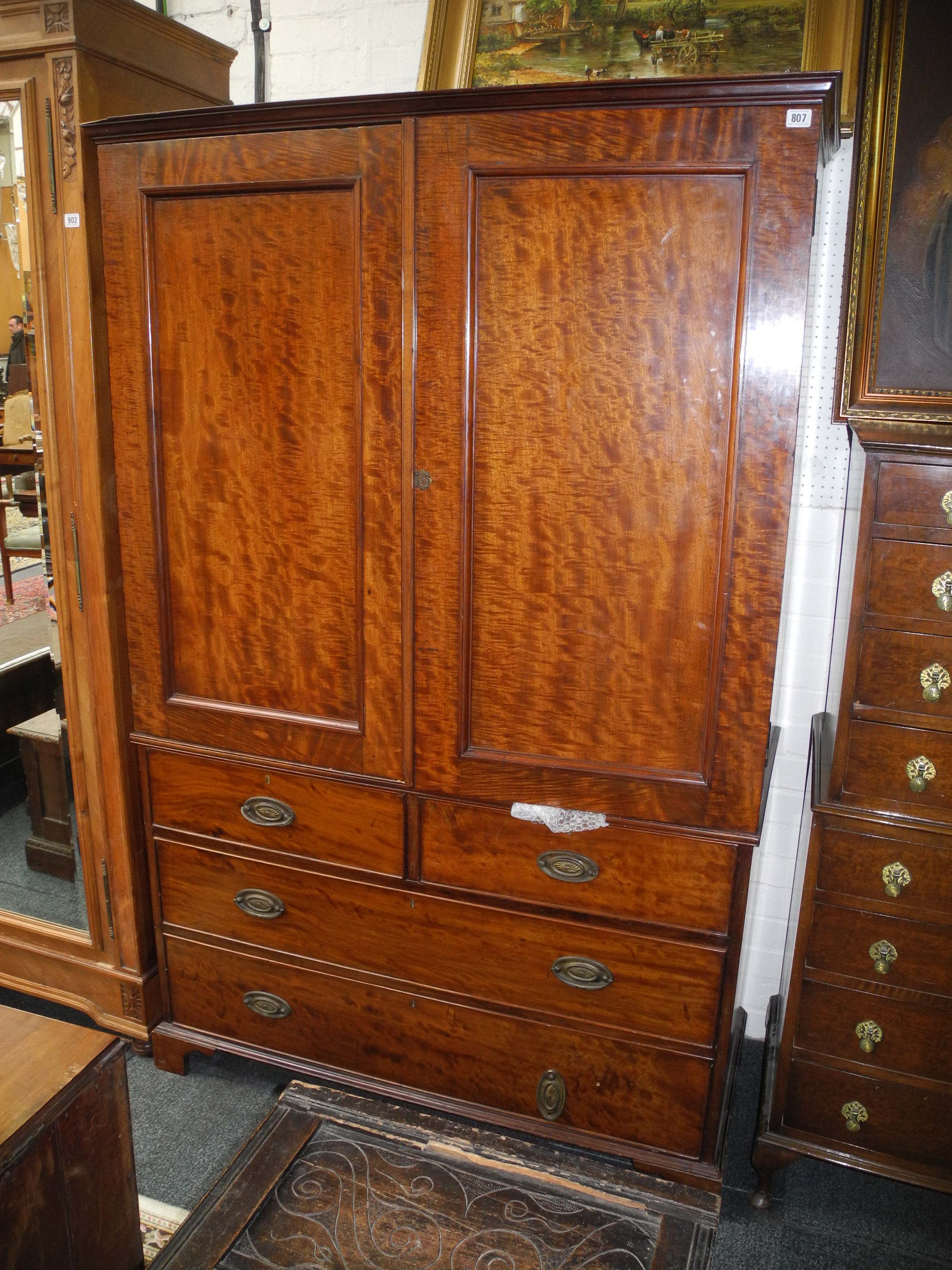 A flame mahogany linen press with two short above two long drawers.