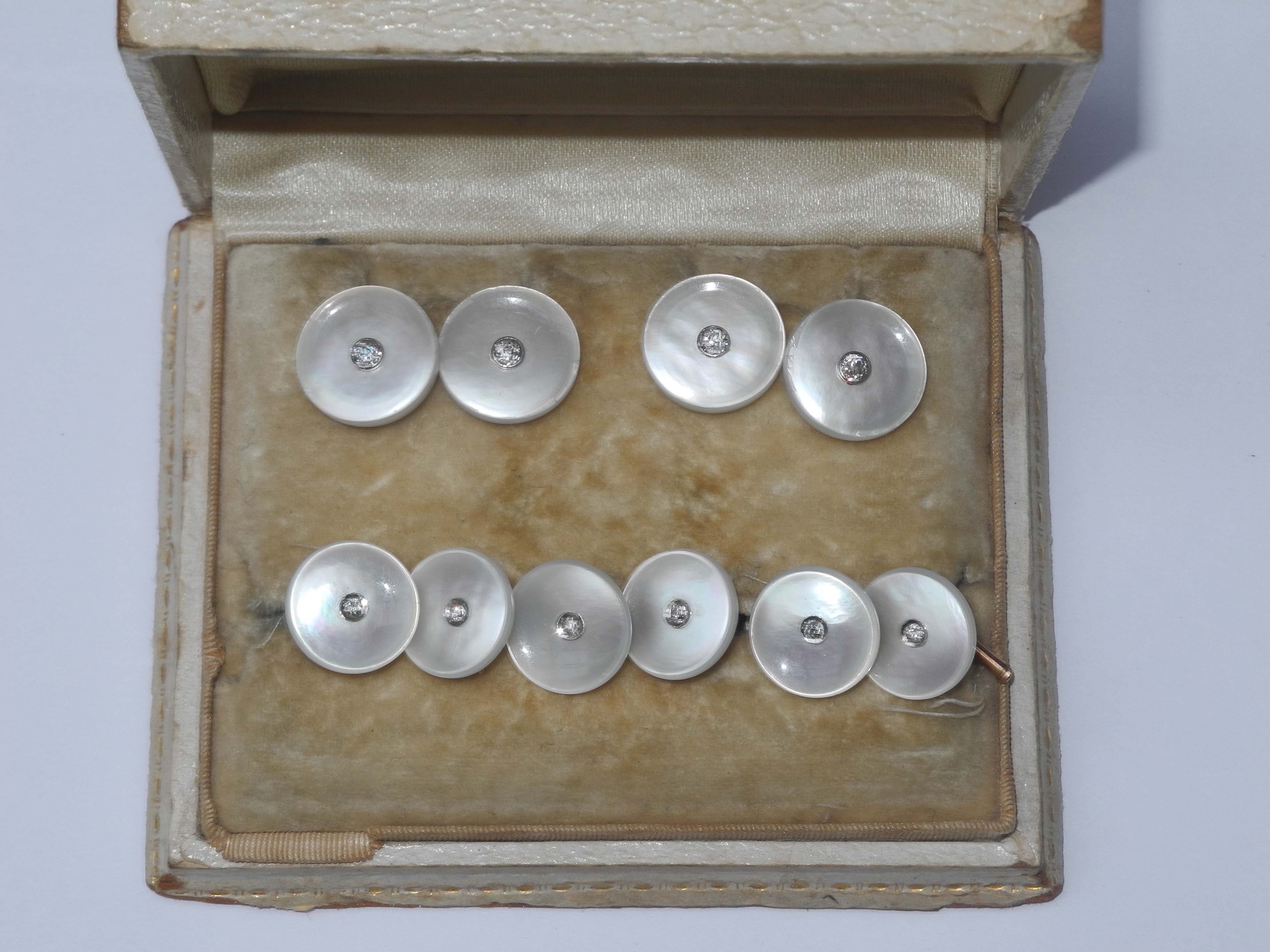 A set of mother-of-pearl and diamond and gold shirt studs, cased.