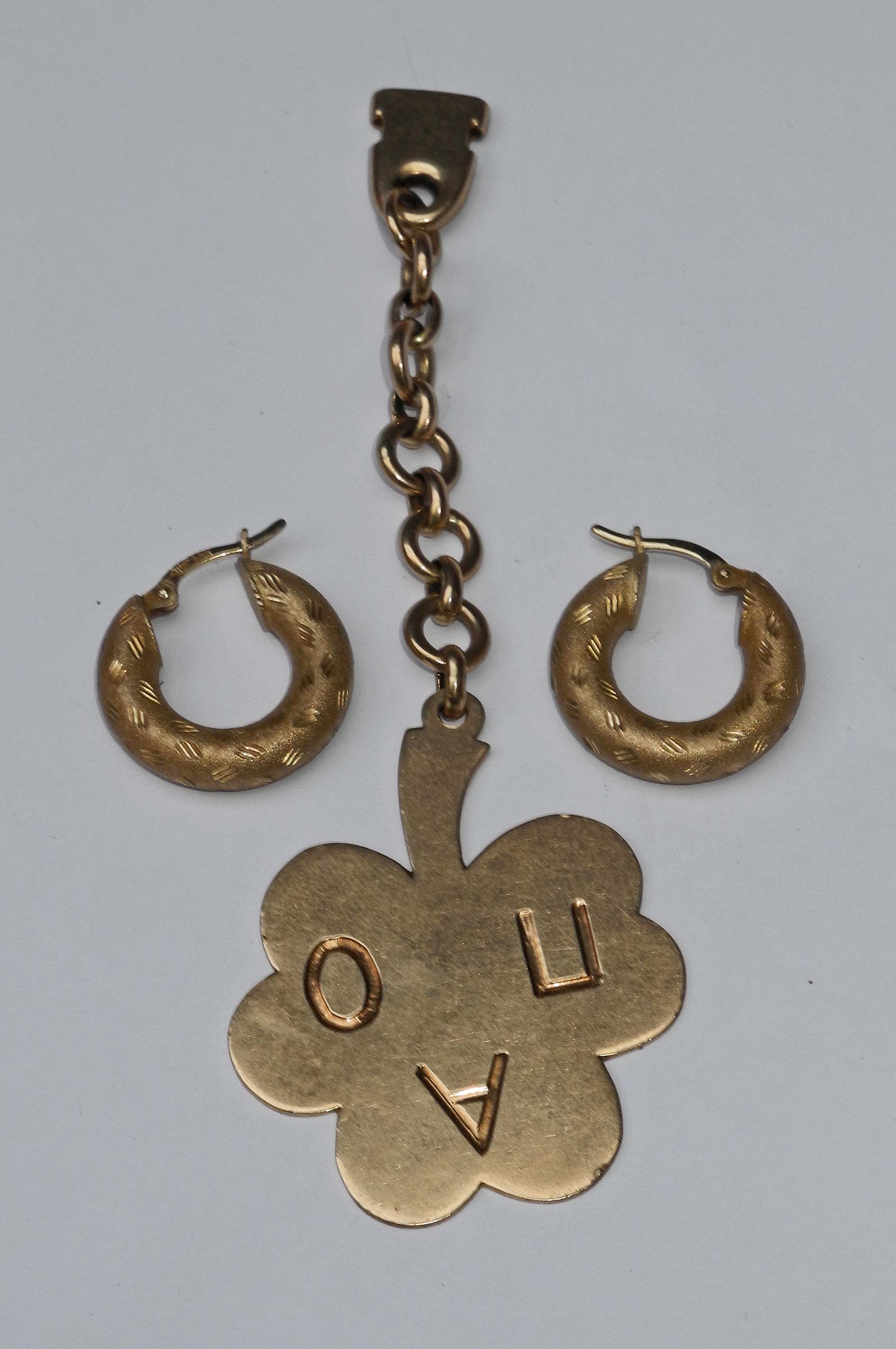 A pair of 14k gold hoop earrings, sold together with a clover leaf on chain. (3)