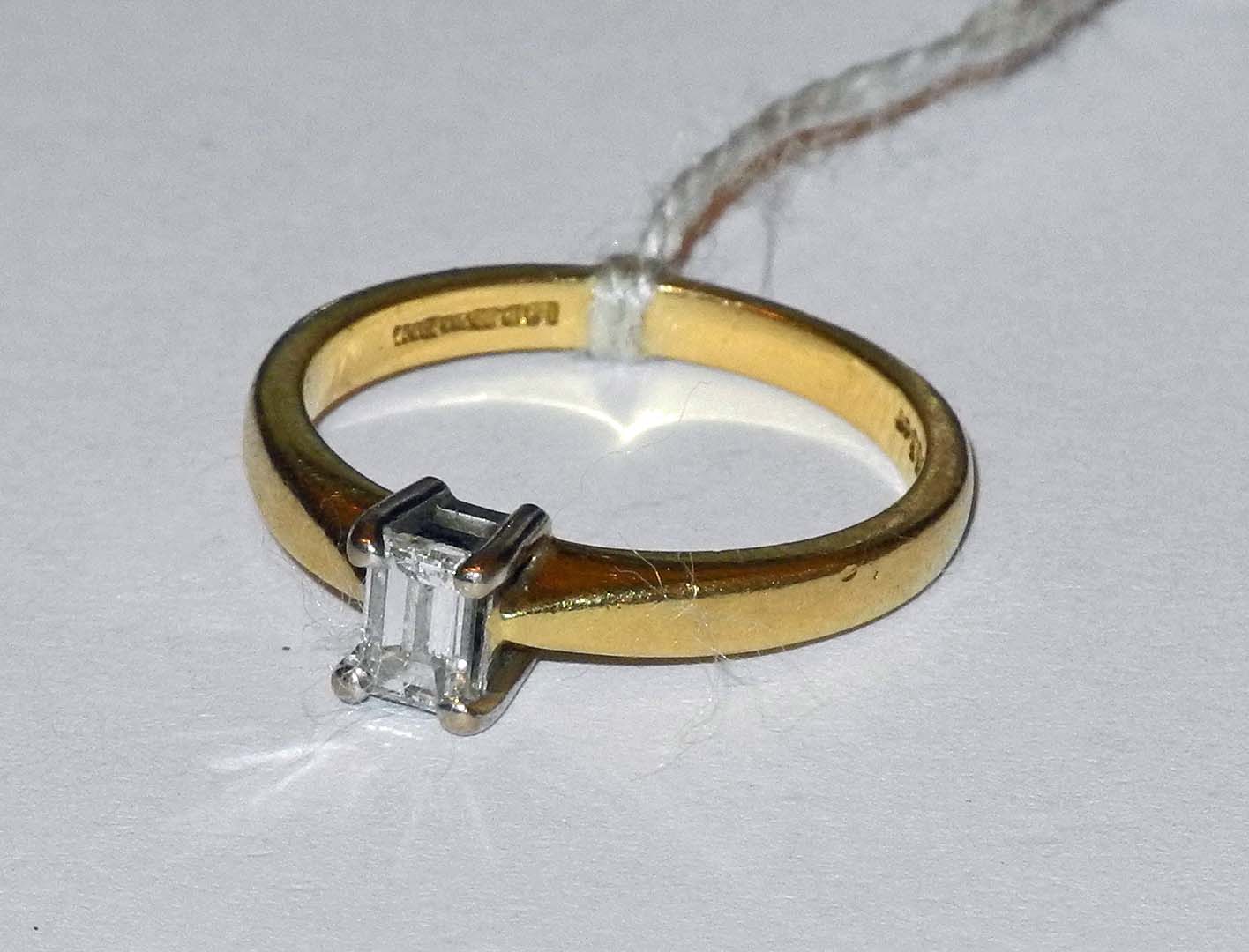 An 18ct yellow gold and diamond solitaire ring, set with a 0.33pt emerald cut stone.