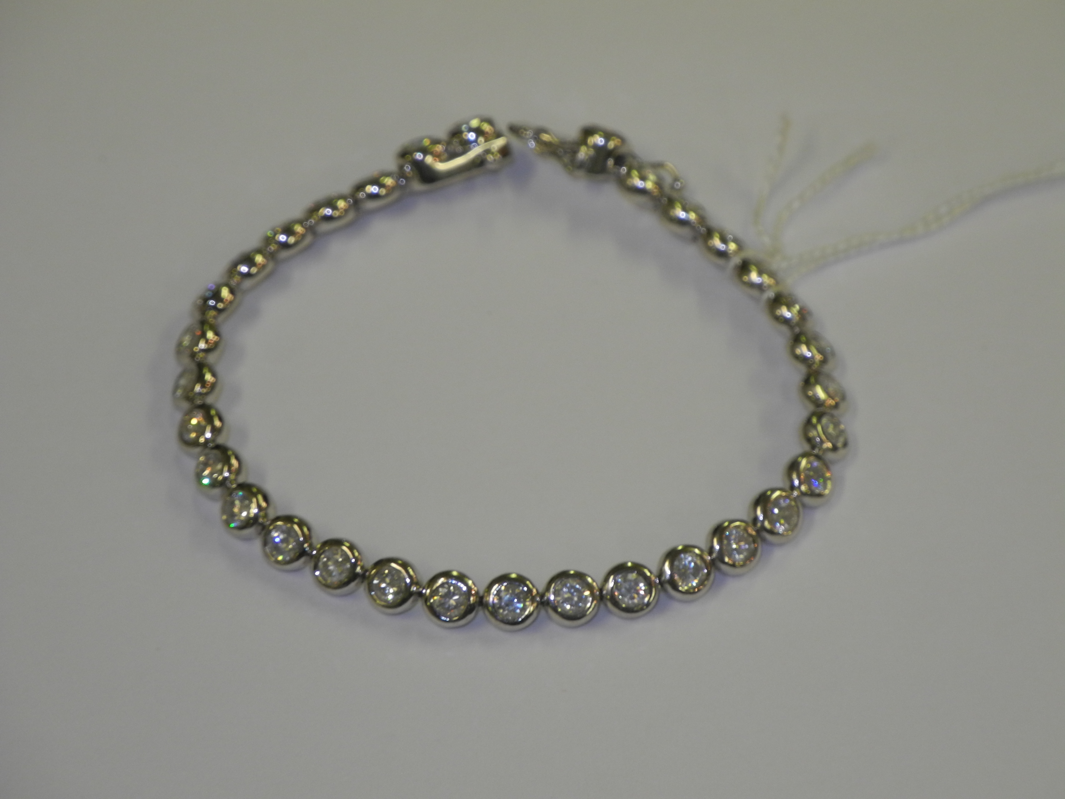 A heavy 18ct white gold and diamond line bracelet, rub over set (4.85ct).