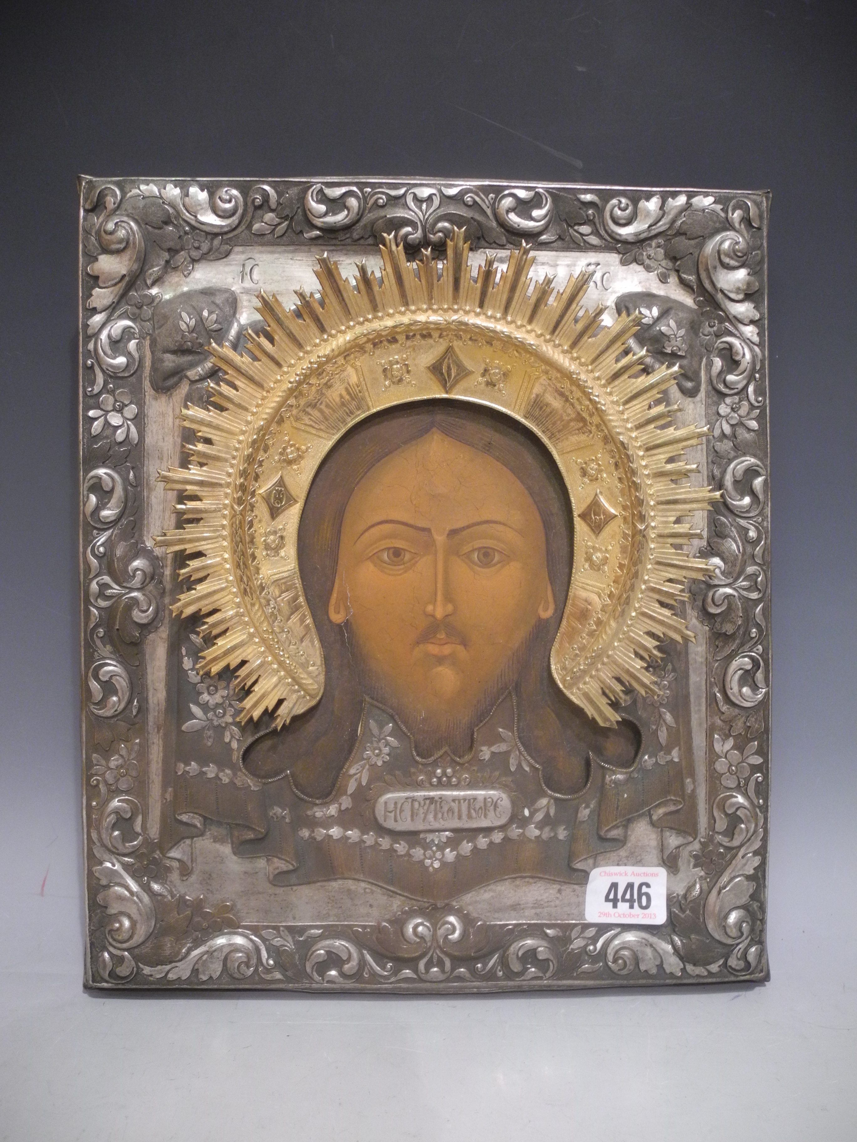 A Russian icon, with metal scroll, leaf and foliate decoration to the frame and gilded ray.31 x 26cm