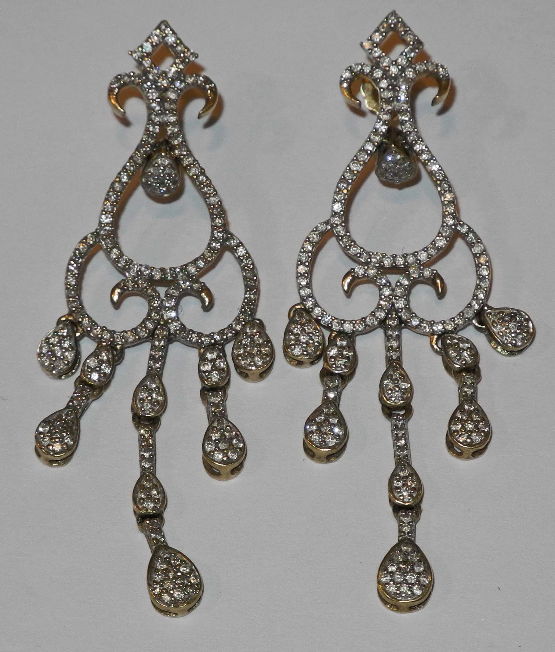 A pair of 9ct gold and diamond set scroll pendant earrings.