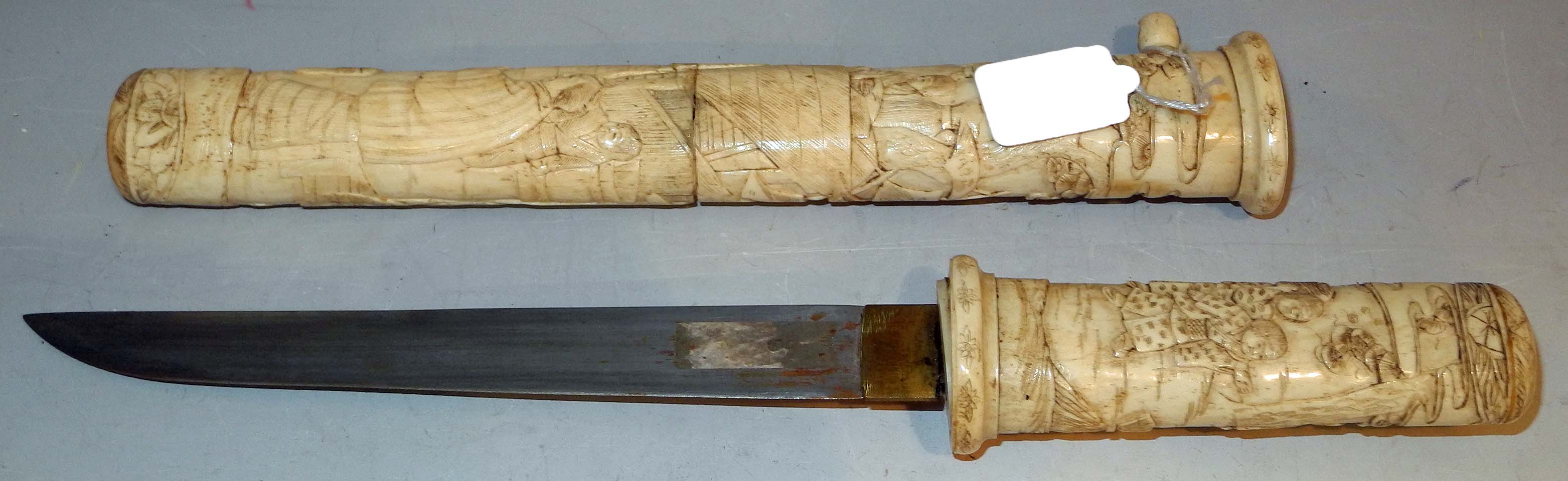 A Japanese tanto dagger, Meiji period, circa 1890, with life scene decorated bone handle and