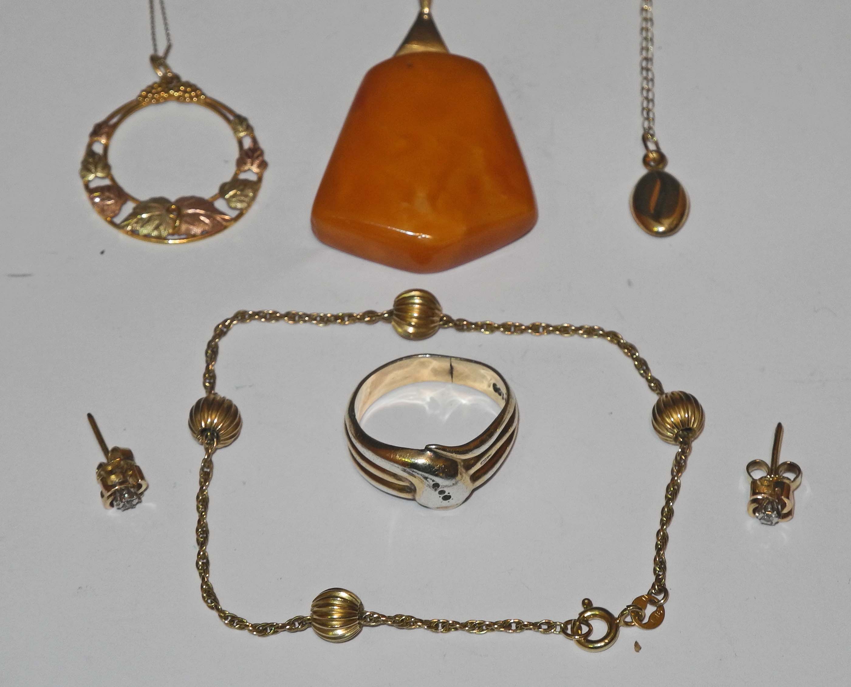 A small collection of 9ct gold jewellery including a necklace, small bangle, amber pendant with