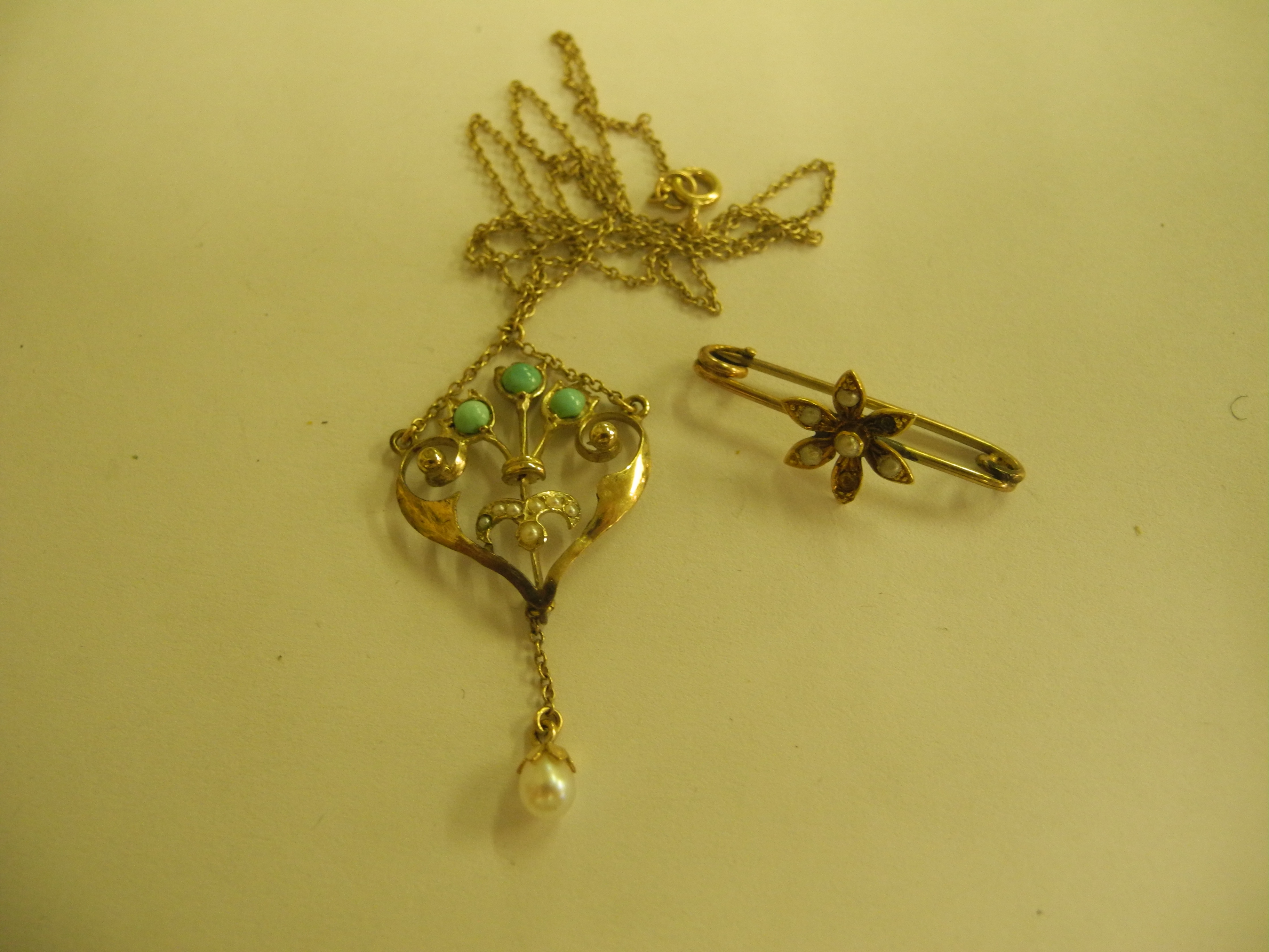 A late Victorian yellow metal Art Nouveau pendant and chain, the pendant set with turquoise and seed