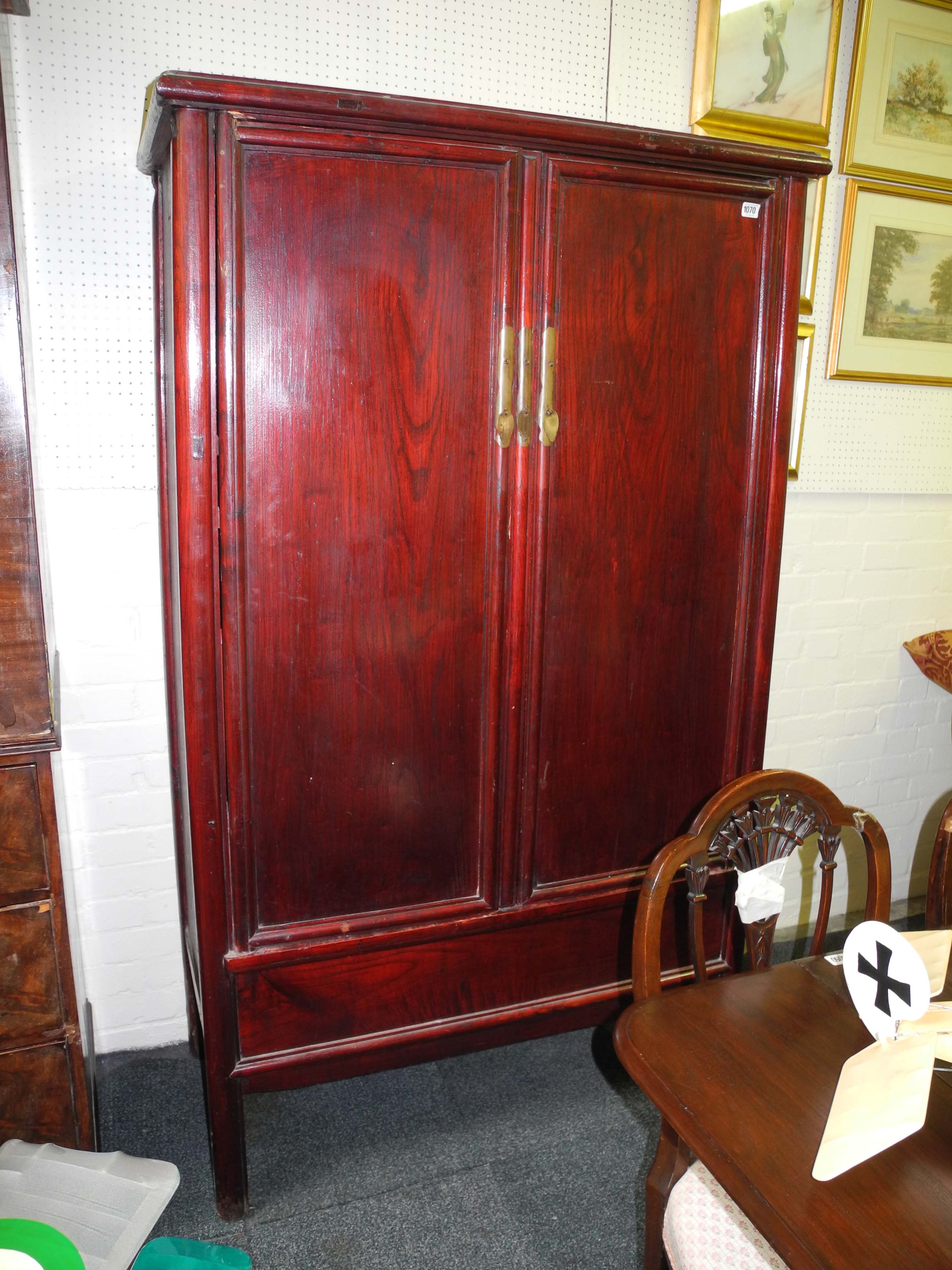 A late 19th Century Chinese provincial red stained elm "marriage" cabinet with two panelled cupboard
