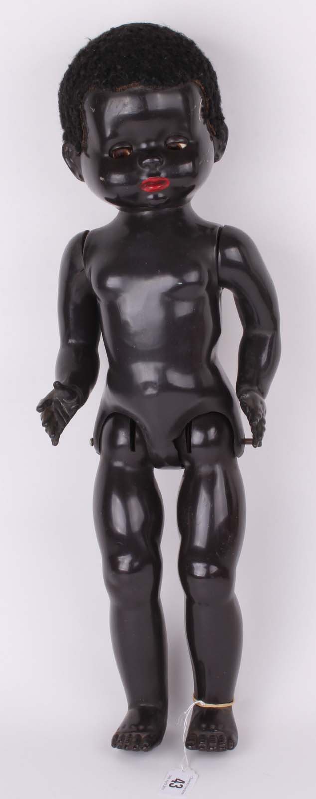 A 1950s Pedigree black walking doll, with flirty eyes, and black curly wig (21") (white mark to