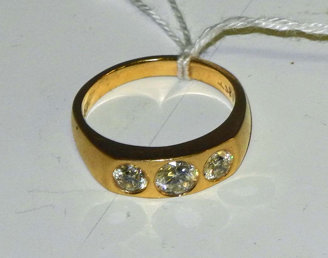 A gentleman`s 18ct yellow gold and diamond set three stone ring, the rub-over brilliant round cut