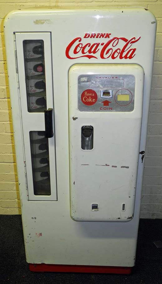 A 1960s upright Coca Cola Cavalier vending machine painted in white with company logos in red