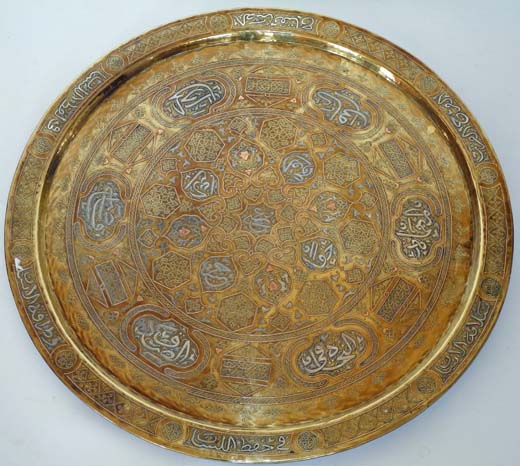 A 19th century circular brass, silver inlaid, Islamic wall hanging plaque, set with cartouches