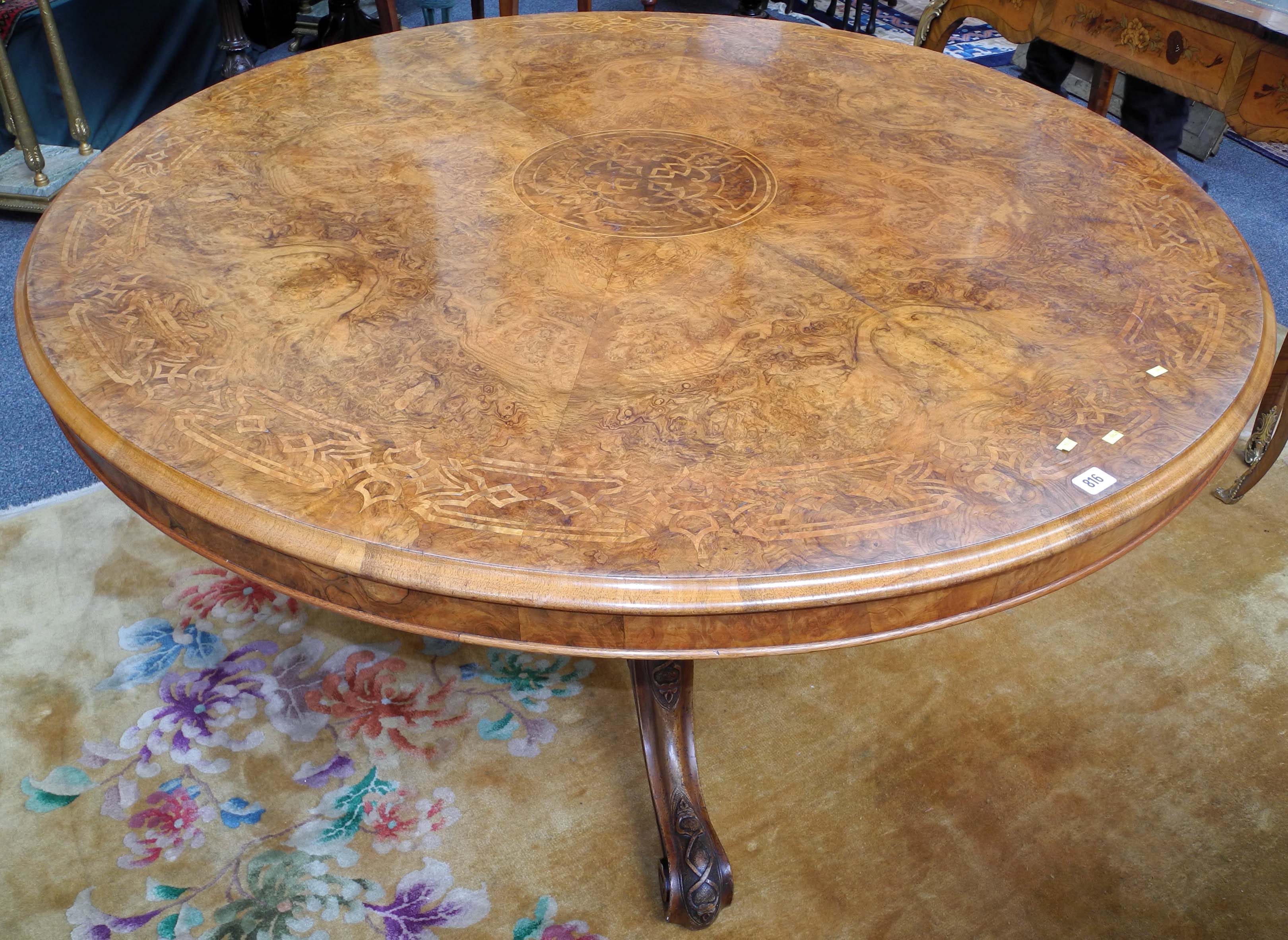 A Victorian burr walnut and marquetry inlaid circular breakfast table, raised on a melon section