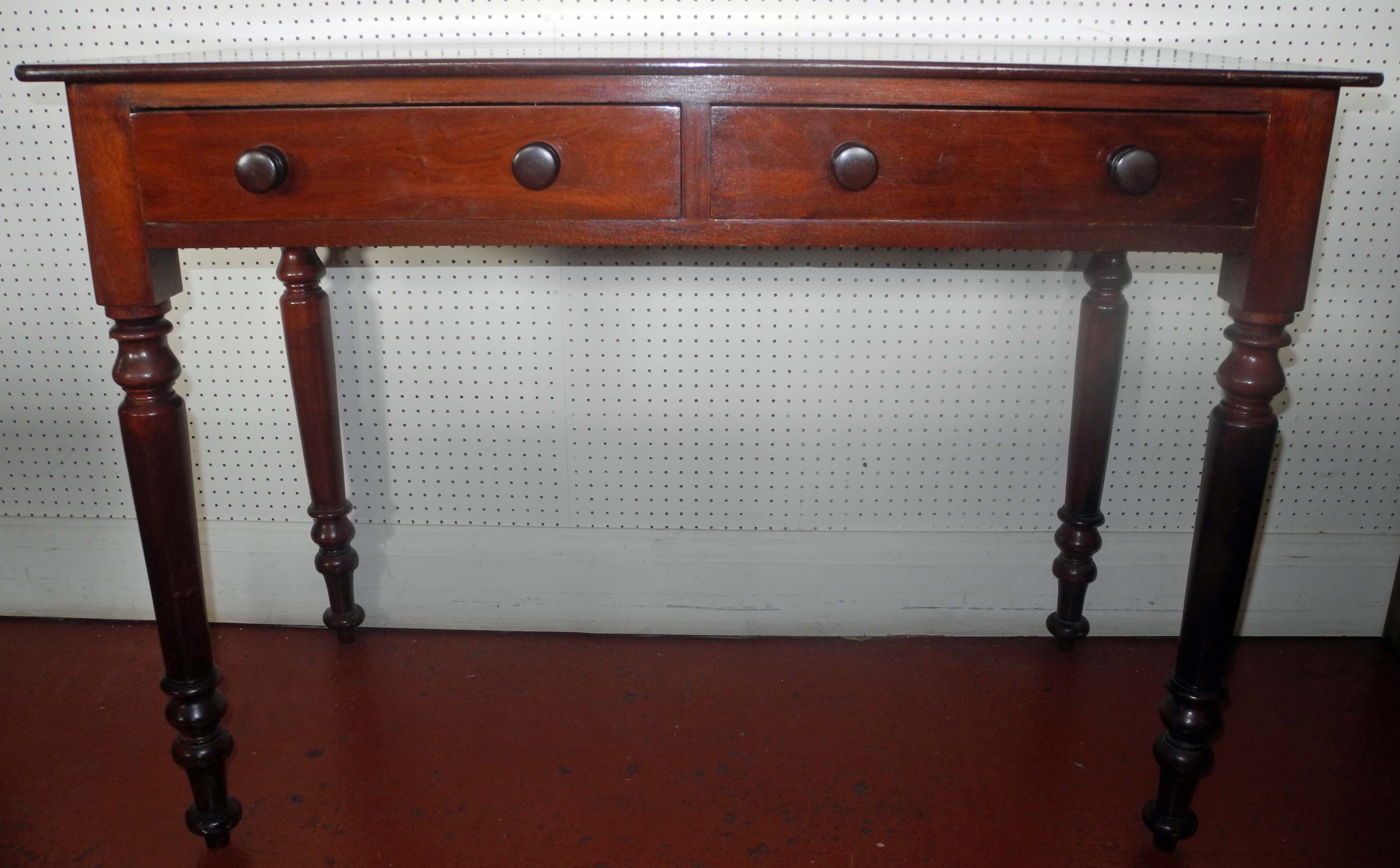 A Victorian Irish mahogany side table with two drawers and raised on turned legs bearing a Dublin