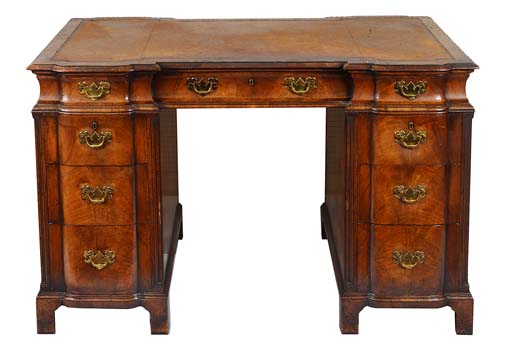 A late 19th/early 20th century walnut twin pedestal desk, the inverted breakfront top inset with a