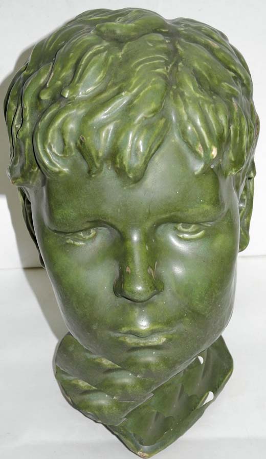 An Art Deco period green drip glazed stoneware bust of a young boy (AF).