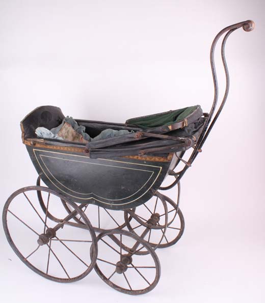 A Victorian doll`s pram with painted green carriage, two inner seats, a green hood, turned wooden