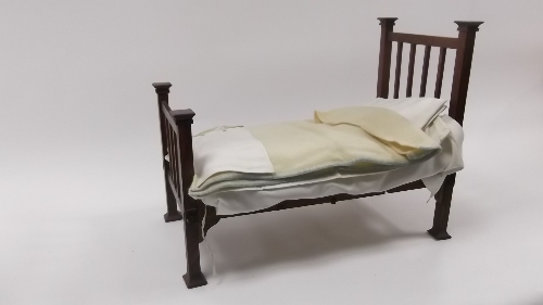 A dolls' 1ft railback bedstead, complete with horsehair mattress and hand-made bedding