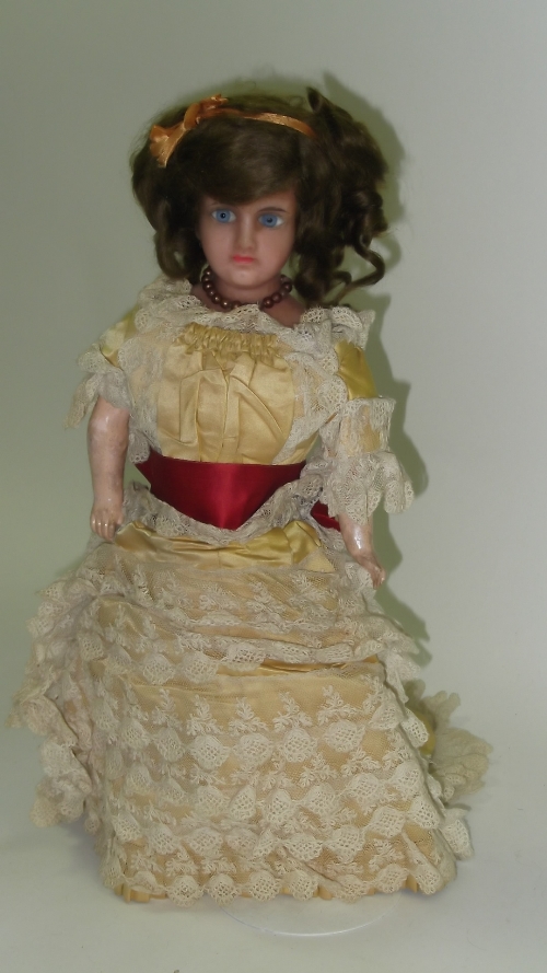 A wax head German doll with composition limbs and cloth covered torso, her head with fixed blue bead