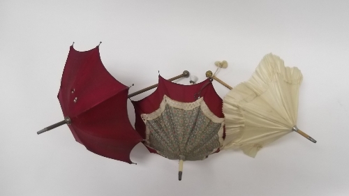 A doll's floral parasol with crimson border and simulated ivory handle with glass finial, a doll's