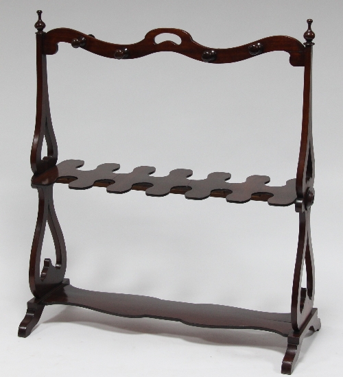 A mahogany whip and boot stand of serpentine outline on lyre end standards and shaped base, 90cm (