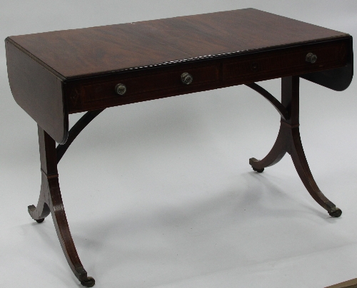 A Regency mahogany sofa table, fitted two drawers on end supports with splay legs with brass caps