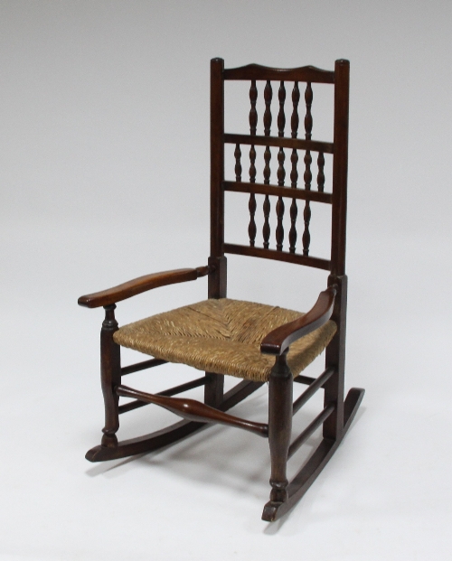 A spindle back rocking chair with rush seat